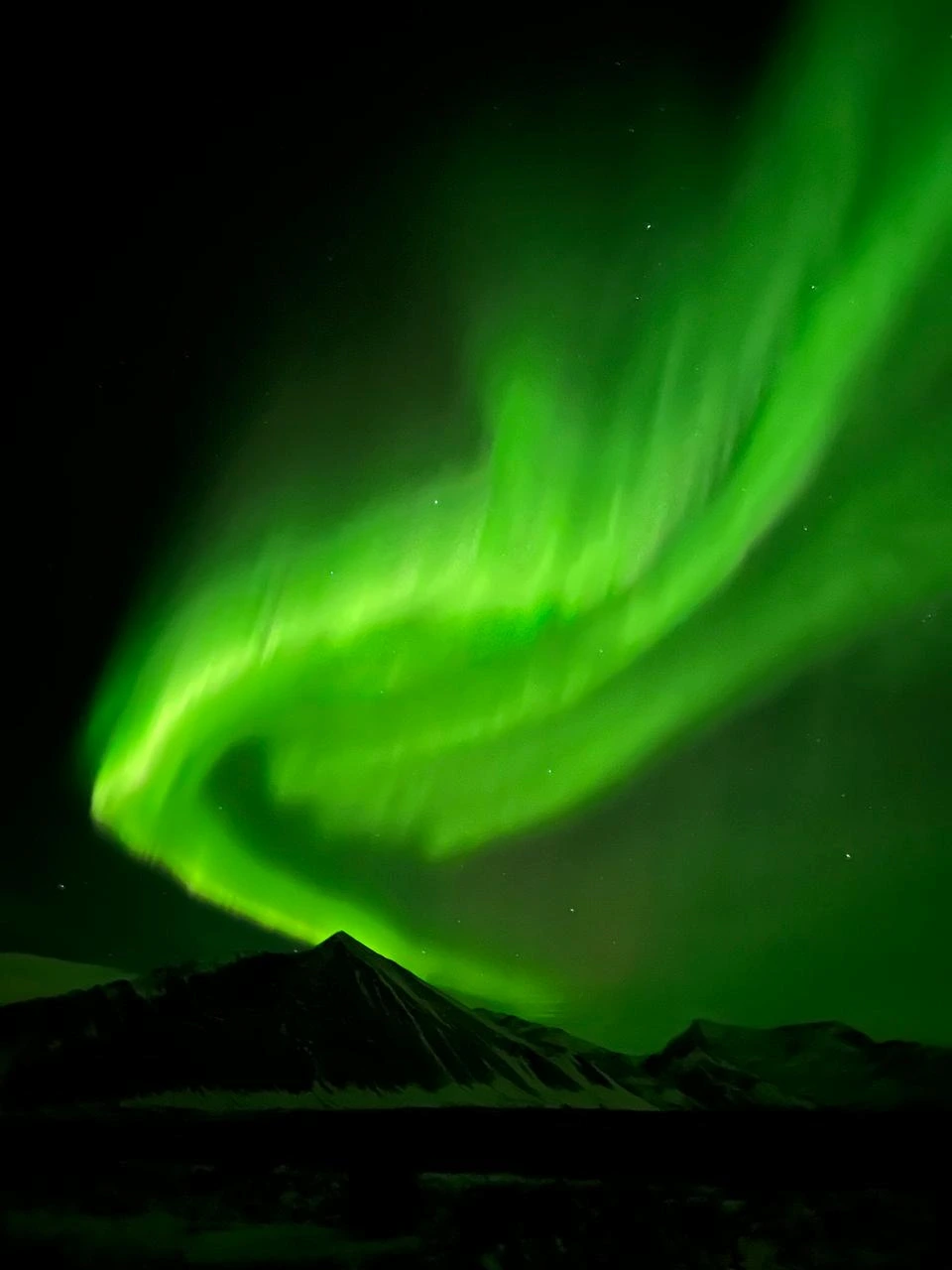Zielona zorza polarna nad islandzkimi górami
